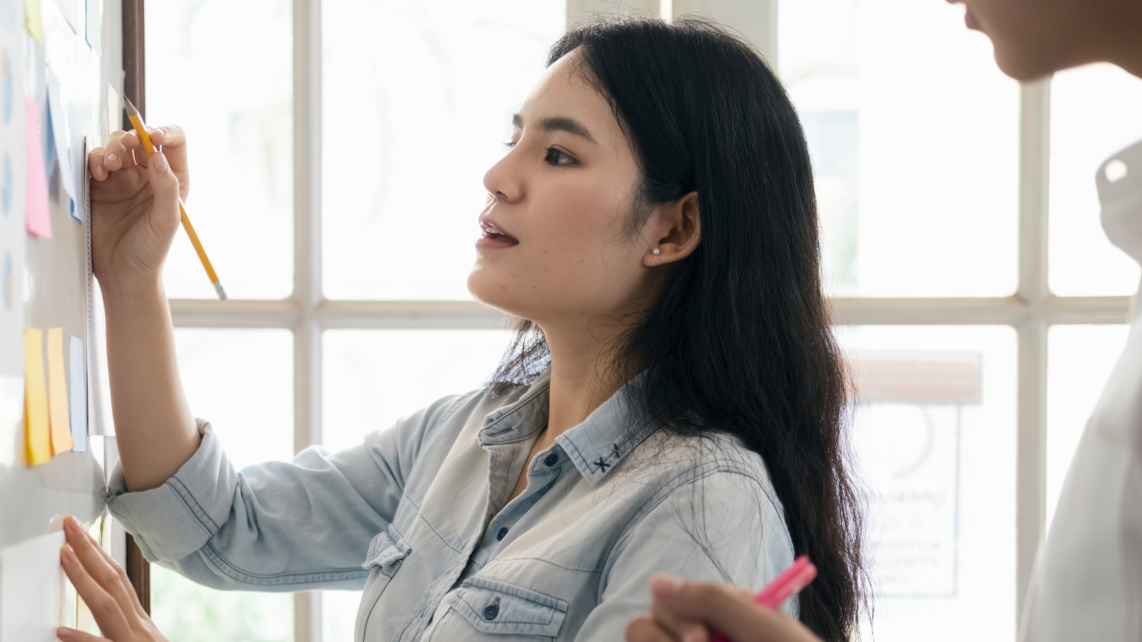 Woman writing on white board